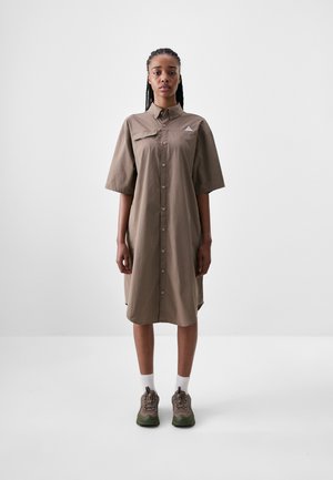 Braunes Kurzarm-Hemdkleid mit Knöpfen und spitzem Kragen. Verfügt über ein kleines Logo auf der Brust und hat eine lockere Passform, die oberhalb der Knie endet.