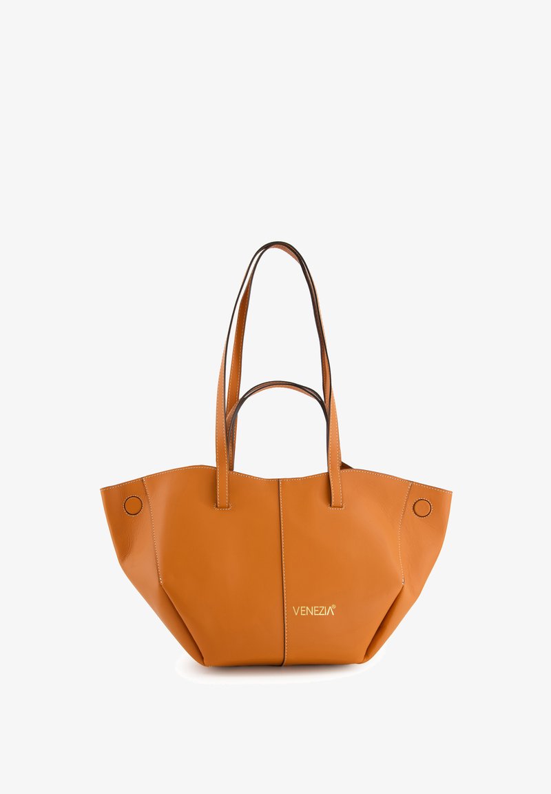 Tote-Bag aus tanfarbenem Leder mit zwei langen Griffen, weiter Öffnung und kontrastierenden Nähten. Verfügt über kreisförmige Akzente und ein markenbezogenes Logo auf der Vorderseite.