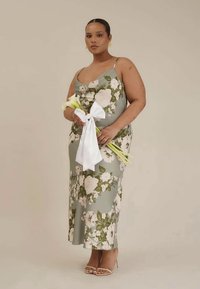 Vestido midi floral em verde, com flores brancas e rosas. Tecido suave, silhueta ajustada, alças finas ajustáveis e rachas laterais.