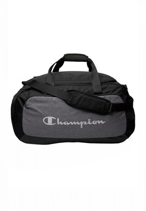 Borsa da viaggio nera e grigia con doppie maniglie, tracolla regolabile e un prominente logo grigio "Champion" sul pannello frontale.
