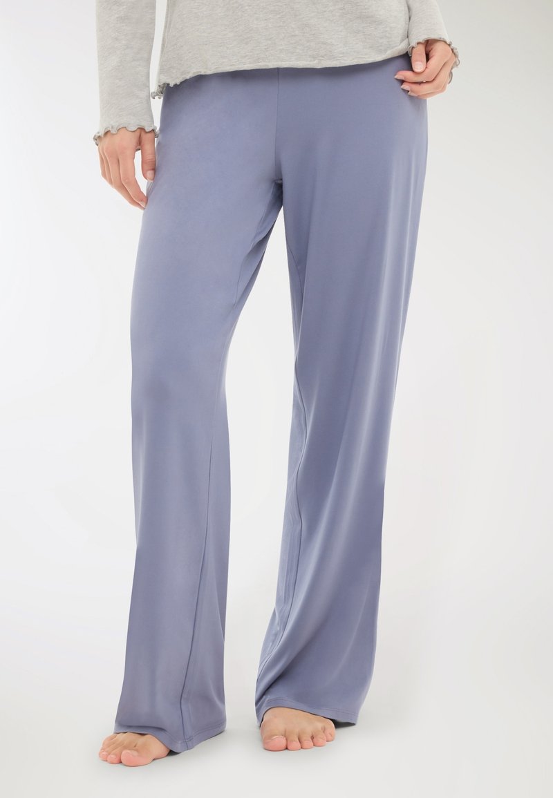Pantaloni leggeri e fluidi in morbido tessuto lavanda. Presentano un design a gamba larga con texture liscia e caduta delicata. L'orlo termina appena sopra il piede.