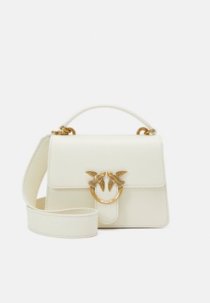 Borsa a mano in pelle bianca con una forma strutturata; presenta un accento hardware ovale color oro con motivi di uccelli e una tracolla rimovibile.