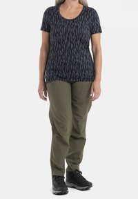 Mörkblå kortärmad skjorta med ett svart abstrakt mönster, tillsammans med olivgröna cargo-byxor och svarta vandringsskor. Bekväm och funktionell design.