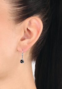 Orecchini a cerchio in argento con un design attorcigliato e un accento nero al centro. Pendono sotto il lobo dell'orecchio e hanno una finitura brillante.