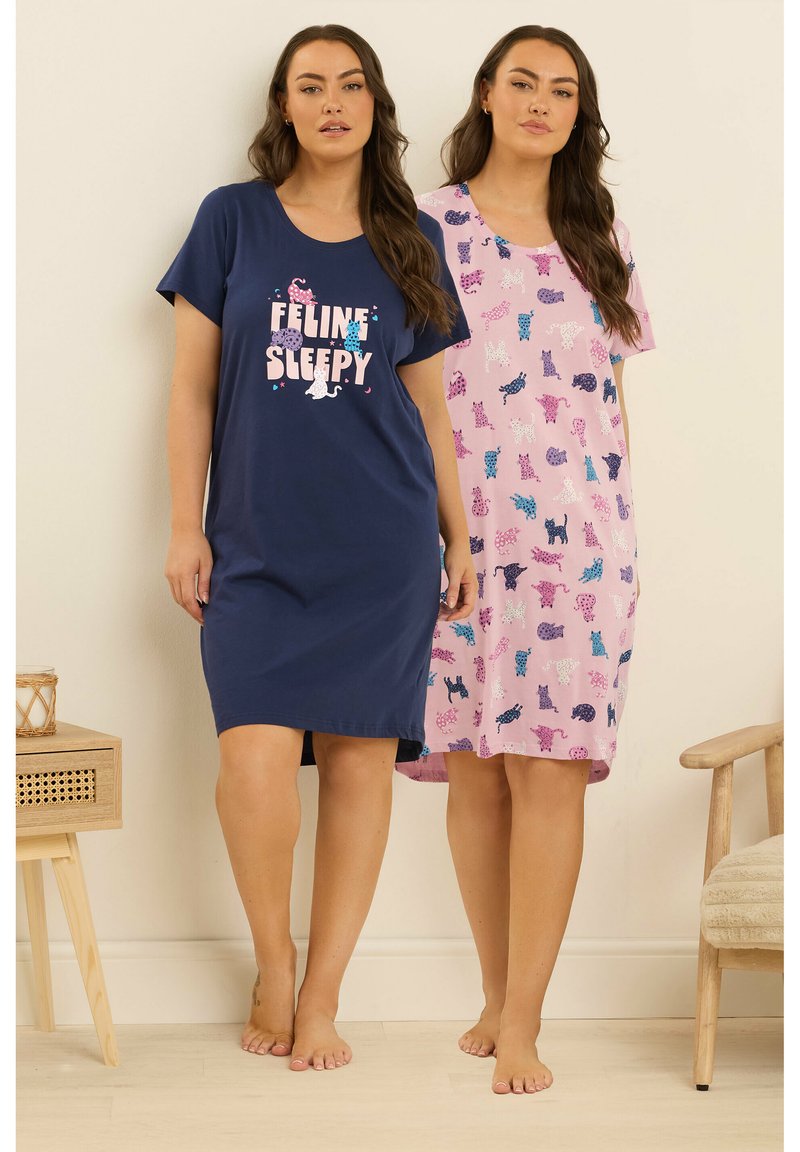 Två kvinnor står barfota iförda knälånga nattskjortor, en marinblå med texten "Feline Sleepy", den andra rosa med flerfärgade katttryck.