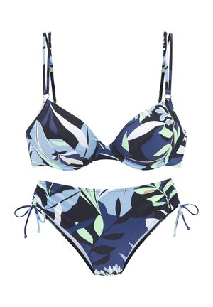 Bikini-Set mit einem geformten Bralette mit verstellbaren Trägern und einem gebundenen Unterteil. Bunte Blättermuster auf einem dunkelblauen Hintergrund.