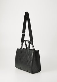 Zwarte vegan leren handtas met een gestructureerd ontwerp, twee bovenhandvatten, een afneembare schouderband en subtiele textuurdetails.