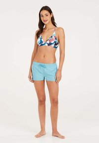 Daugiagaražinė bikini viršutinė dalis su geometriniais raštais; šviesiai mėlyni maudymosi šortai su elastinga juosta ir raišteliu.