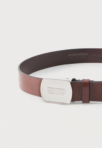 Καφέ δερμάτινη ζώνη με ορθογώνιο ασημένιο αγκράφα χαραγμένο με το "DSQUARED2 Born in Canada Made in Italy."