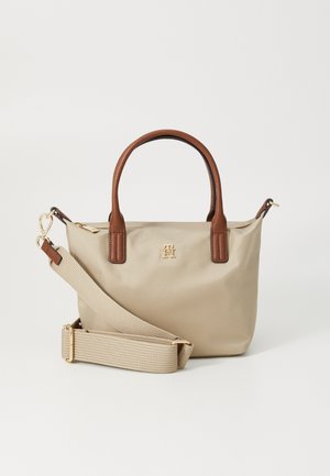 Beige handtas met bruine handvatten, een afneembare brede beige stoffen schouderriem en een klein gouden logo in het midden onder de rits.