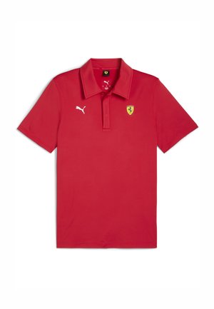Cămașă polo roșie dintr-un material fin, cu guler, mâneci scurte, un logo alb Puma și un emblema Ferrari pe piept.
