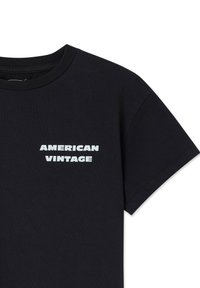 T-shirt noir à manches courtes en coton doux, avec le texte blanc "AMERICAN VINTAGE" sur la partie supérieure gauche. Design classique à col rond.