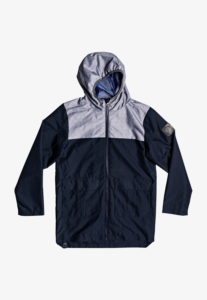 Veste à capuche à manches longues avec moitié inférieure bleu marine, moitié supérieure grise texturée, fermeture éclair frontale, deux poches avant et écusson sur la manche gauche.