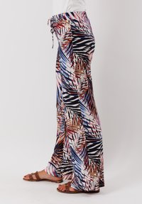 Pantaloni a gamba larga colorati e a motivo, caratterizzati da un design con foglie tropicali in blu, rosso e beige. Realizzati in tessuto leggero con una vita elastica.