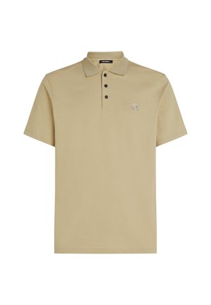 Beidža polo krekls, kas izgatavots no mīksta auduma, ar apkakli, īsām piedurknēm, trim melniem pogām un nelielu izšūtu logotipu uz krūškurvja.