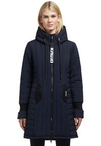 Navy blue padded coat with a zip front, adjustable hood, ribbed cuffs, side pockets, and vertical stitching for texture.