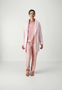 Pink fleece robe over a matching pink set. The robe has a shawl collar and waist tie. Soft texture with long sleeves and loose fit pants.