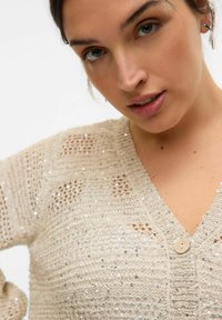 Cardigan lavorato a maglia beige con scollatura a V, chiusura con un solo bottone e paillettes sparse per un tocco di texture e brillantezza.