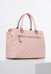 Vaaleanpunainen tikattu käsilaukku, jossa on kaksinkertaiset kahvat, vetoketjullinen etutasku ja kullanväriset metalliosat. Sileä, kiiltävä materiaali.