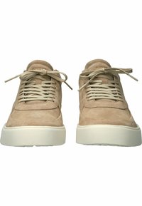 Zapatillas de ante beige con una textura suave, punta redondeada y suela plana de goma blanca. Presentan cordones planos y detalles de costura.