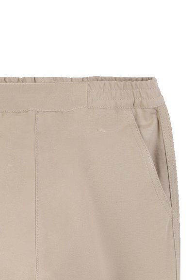 Beige broek met een elastische tailleband, zijzakken en een gladde textuur. Heeft subtiele stiksels langs de naden voor duurzaamheid.