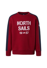 Felpa rossa con pannelli laterali blu navy. Presenta un grande testo bianco "NORTH SAILS", l'anno "1957" e un piccolo logo sulla manica.