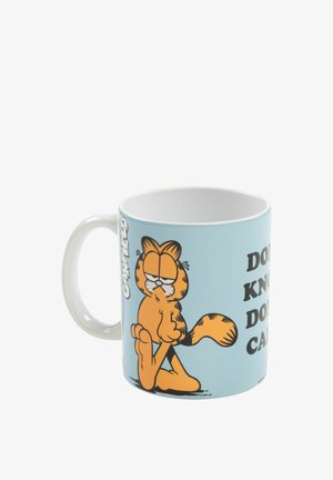 Keramiktasse mit einer cartoonhaften Katze auf einem hellblauen Hintergrund. Der Text lautet: "WEISS NICHT, INTERESSIERT NICHT." Weiße Griffe, glanz finish.