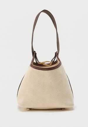 Mala bež platnena torba s smeđim kožnim obrubom, jednim remenom za rame, zlatnom kopčom i zaobljenim dnom s metalnim nogicama.