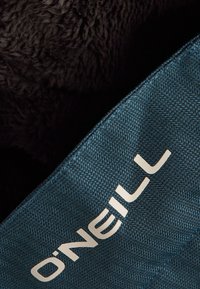 Teal fabric with a textured surface, featuring a black, fluffy backing. The brand name "O'Neill" is prominently displayed in white.