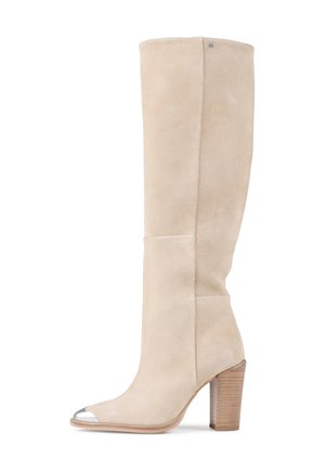 Botte haute en suède beige avec un bout ouvert, accent argenté sur le bout de la chaussure et un talon en bois texturé.