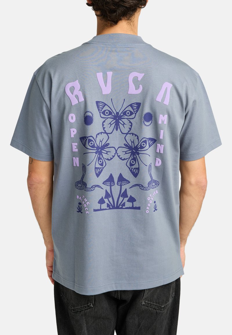 Camiseta de algodón gris con un gran gráfico en la parte posterior que presenta diseños de mariposas moradas y azules, champiñones y el texto "MENTE ABIERTA" con elementos decorativos.