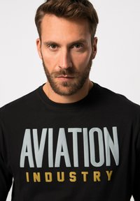 Schwarzer Sweater mit auffälligem "AVIATION"-Text in Hellblau und "INDUSTRY" in Gold. Crew-Neck-Design mit weichem, baumwollartigem Material.