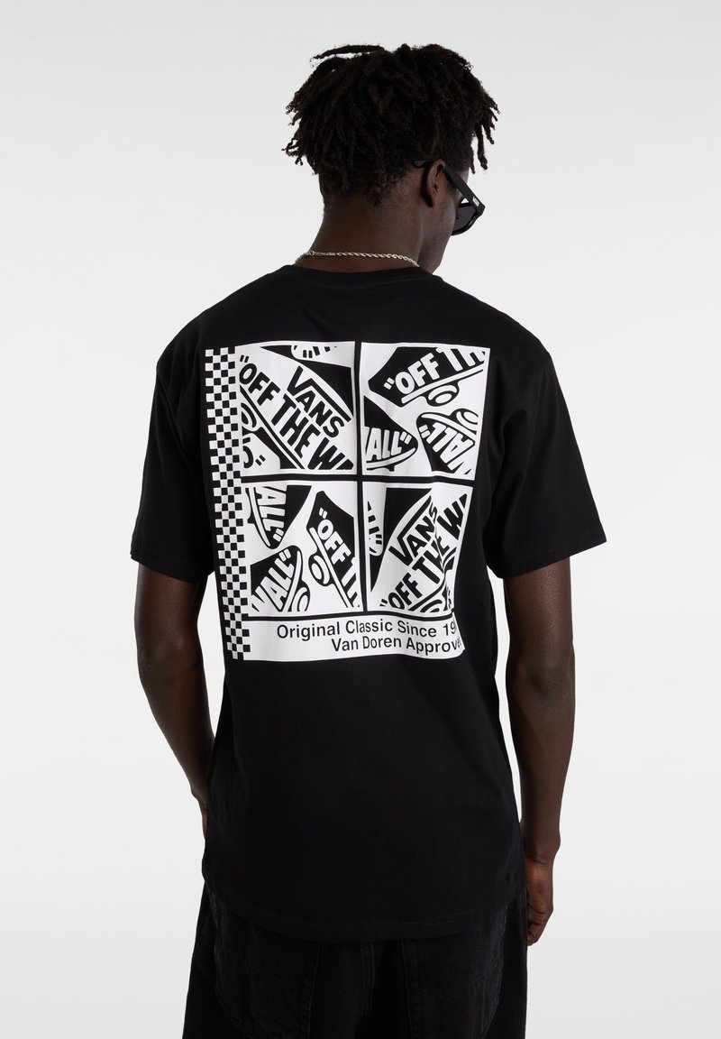 Camiseta negra con un diseño gráfico que incluye texto y patrones a cuadros en la parte posterior. Material de algodón con un corte relajado y mangas cortas.