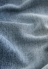 Tavaline denimkangas, mis on kudumistehnikaga twill, omab keskmiselt sinist värvi ja peent tekstureeritud pinda. Näitab loomulikult voldid ja langeb.
