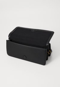 Borsa nera con chiusura magnetica, esterno in pelle liscia, interno spazioso e tracolla removibile. Nessun motivo o dettaglio visibile.