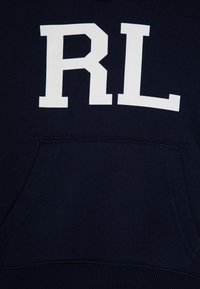 Námořnická modrá mikina s kapucí, na přední straně s bílým logem "RL", s klokankovou kapsou a žebrovanými manžetami a lemem. Měkký bavlněný materiál.