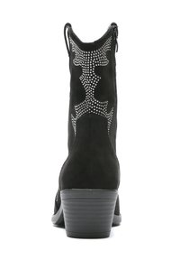 Botines de ante negro con tachuelas decorativas plateadas, un tacón ligeramente curvado y cierre de cremallera en la parte trasera. Tacón texturizado y un interior suave.