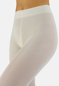 Medias de color beige claro con una textura suave, que presentan una cintura alta y un diseño acanalado para mayor comodidad. Cobertura transparente con un aspecto sin costuras.