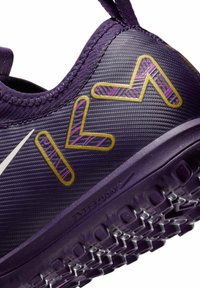 Scarpa sportiva viola in materiale strutturato, con accenti stilizzati gialli e rosa. Nota linguetta sul tallone e design della suola durevole.