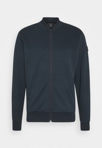 Giacca navy con chiusura a zip, collo aderente, due tasche frontali e polsini a costine. Realizzata in tessuto liscio con design a tinta unita.