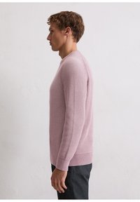 Light pink knitted sweater featuring a round neckline, long sleeves, a textured pattern, and ribbed cuffs and hem.