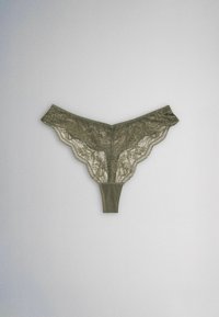 String en dentelle vert olive avec motifs floraux et bords festonnés, posé à plat sur un fond blanc.