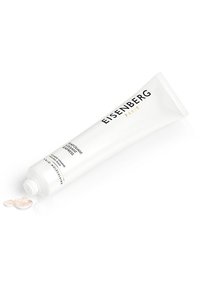 Tube en plastique blanc de crème exfoliante, étiqueté "Eisenberg Paris", avec un accent argenté ; texture lisse ; petite quantité de crème pressée.