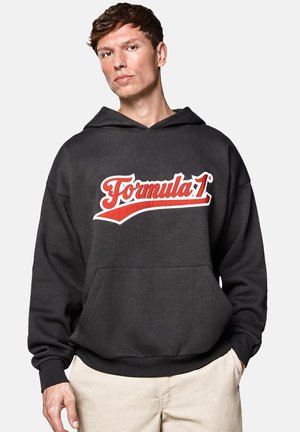 Czarna bluza z kapturem z przednią kieszenią kangurką, z czerwono-białym logo "Formula 1" na piersi. Miękka tkanina, luźny krój.