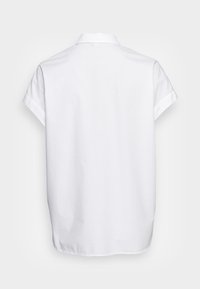 Chemise blanche à manches courtes avec un col pointu, confectionnée dans un tissu léger. Vue de dos montrant une coupe droite et des détails de coutures discrètes.