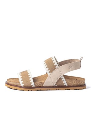 Sandalia beige y blanca con puntera abierta, dos tiras cruzadas sobre el pie y suela con textura de corcho con base de goma.