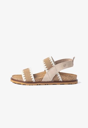 Beige-weiße Sandale mit offenen Zehen, zwei Riemen, die den Fuß überkreuzen, und einer korktexturierten Sohle mit gummierter Laufsohle.