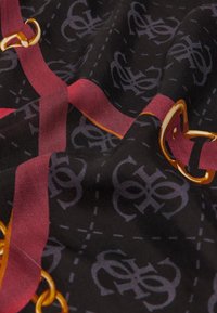 Écharpe en soie avec une base noire ornée de motifs de logo violets, de rayures bordeaux et d'accents en or, créant une apparence texturée.