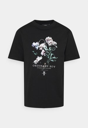 Czarny t-shirt z krótkim rękawem z kwiatowym wzorem i białym napisem „ORDINARY BOY STANDING ALONE” na przodzie.