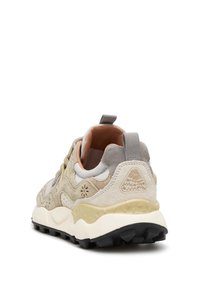 Sneaker in suede beige e grigio con suola texturizzata, dotata di un tab di estrazione, design stratificato e logo triangolare sul tallone.